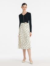 A lady wears a white skirt with polka dots.